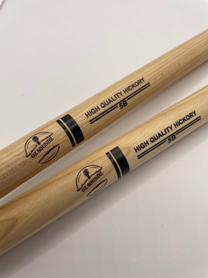 Two Hickory 5B drumsticks with 'Oz Soundz' branding on a white background