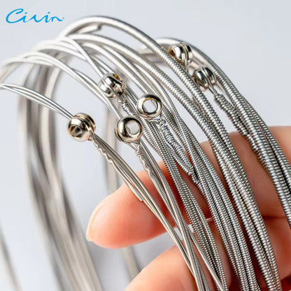 Close up Bass Guitar Strings Silver held by a hand with a light gray background