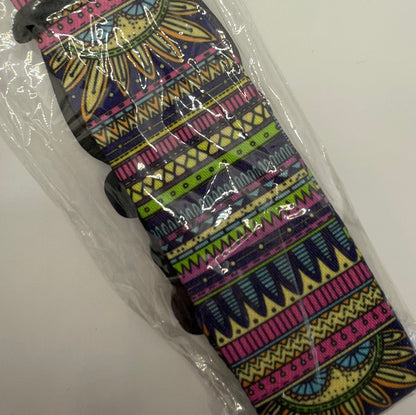 Colorful patterned guitar strap with plastic wrap on a white background