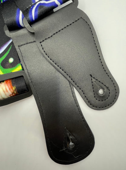 Close-up of a black leather guitar strap connectors with colourful pattern on a white background